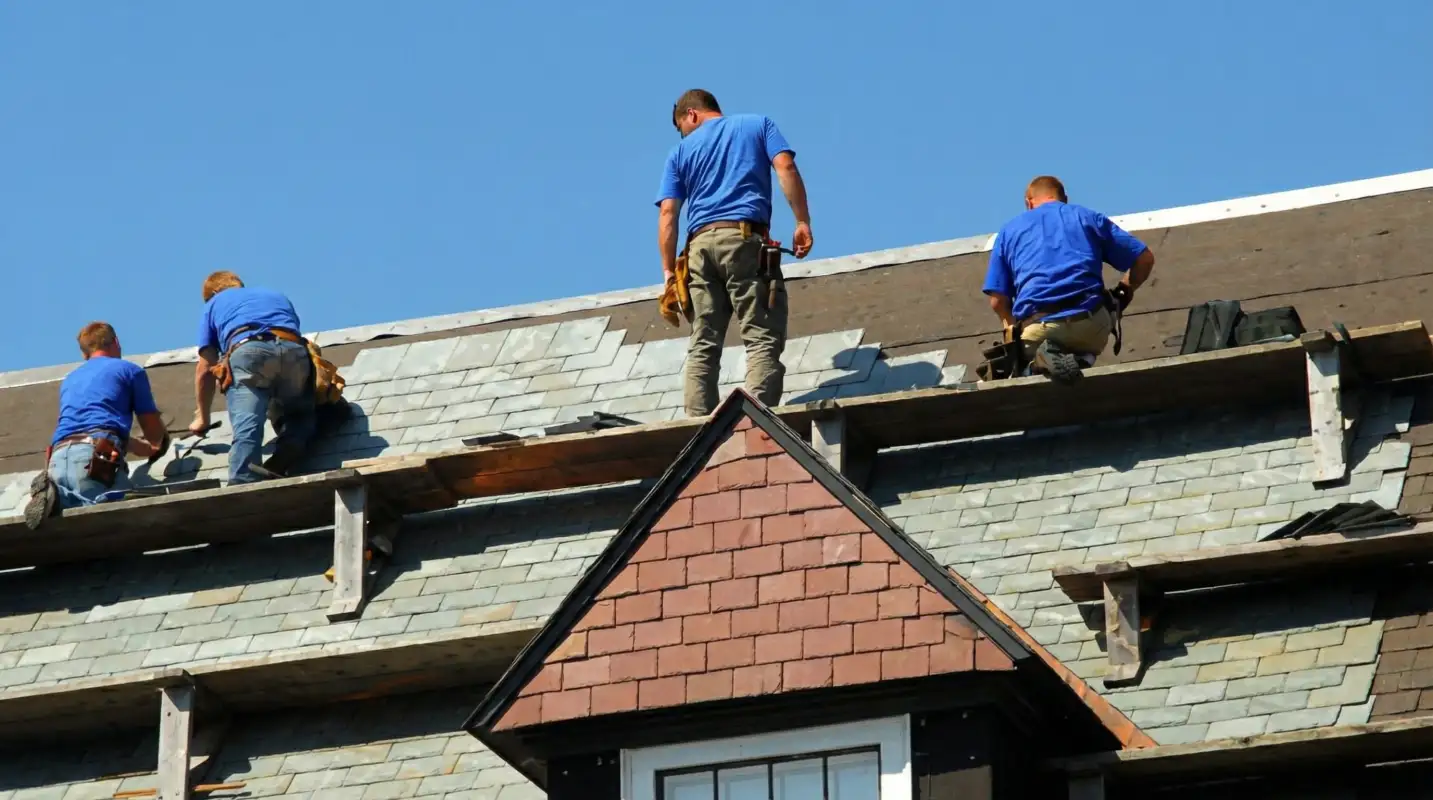 Roof replacement in progress with a team of professional contractors installing new shingles on a residential home in Syracuse, NY